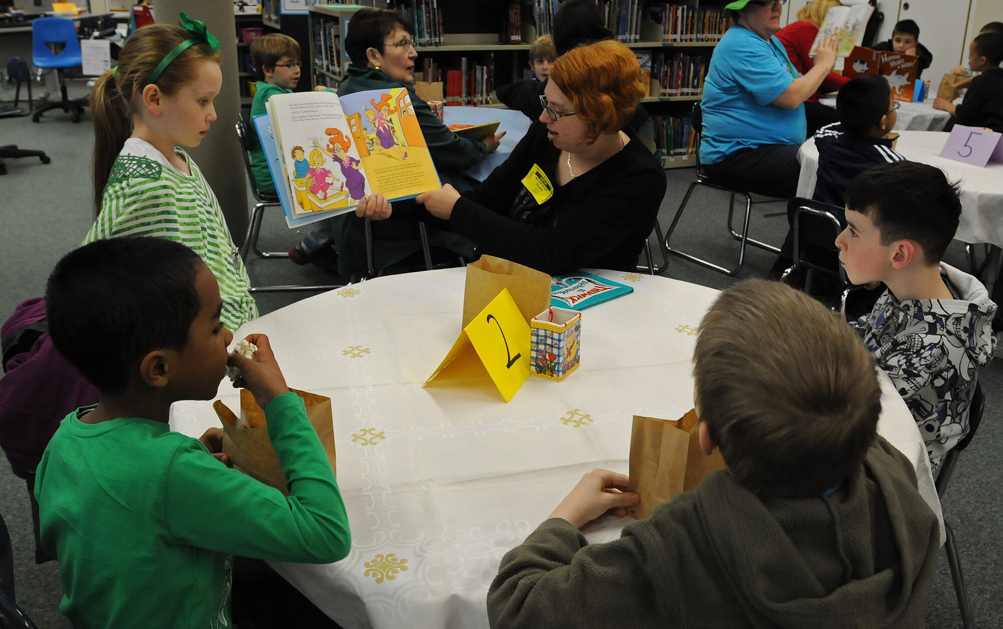 Lee Holman, wife of Staff Sgt. Jeremy Holman, 86th Vehicle Readiness Squadron vehicle mechanic, reads to Ramstein Elementary School students at the reading café during Read Across America week Mar. 3, 2014, Ramstein Air Base, Germany. Read Across America is a week-long celebration, held the week of Dr. Seuss’ birthday, to teach children the importance of reading and education in schools across America and U.S. military installations overseas. (U.S. Air Force photo/Airman 1st Class Holly Mansfield)