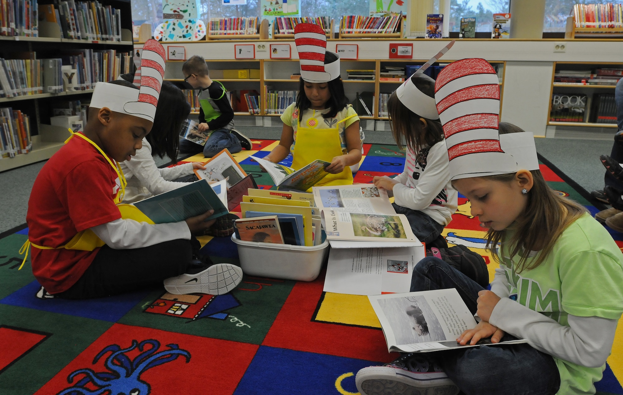 Students of Bonnie Grimes’ second grade class read during a break from serving popcorn and seating younger children at the reading café at Ramstein Elementary School during Read Across America week Mar. 3, 2014, Ramstein Air Base, Germany. Read Across America is a week-long celebration, held the week of Dr. Seuss’ birthday, to teach children the importance of reading and education in schools across America and U.S. military installations overseas. (U.S. Air Force photo/Airman 1st Class Holly Mansfield)