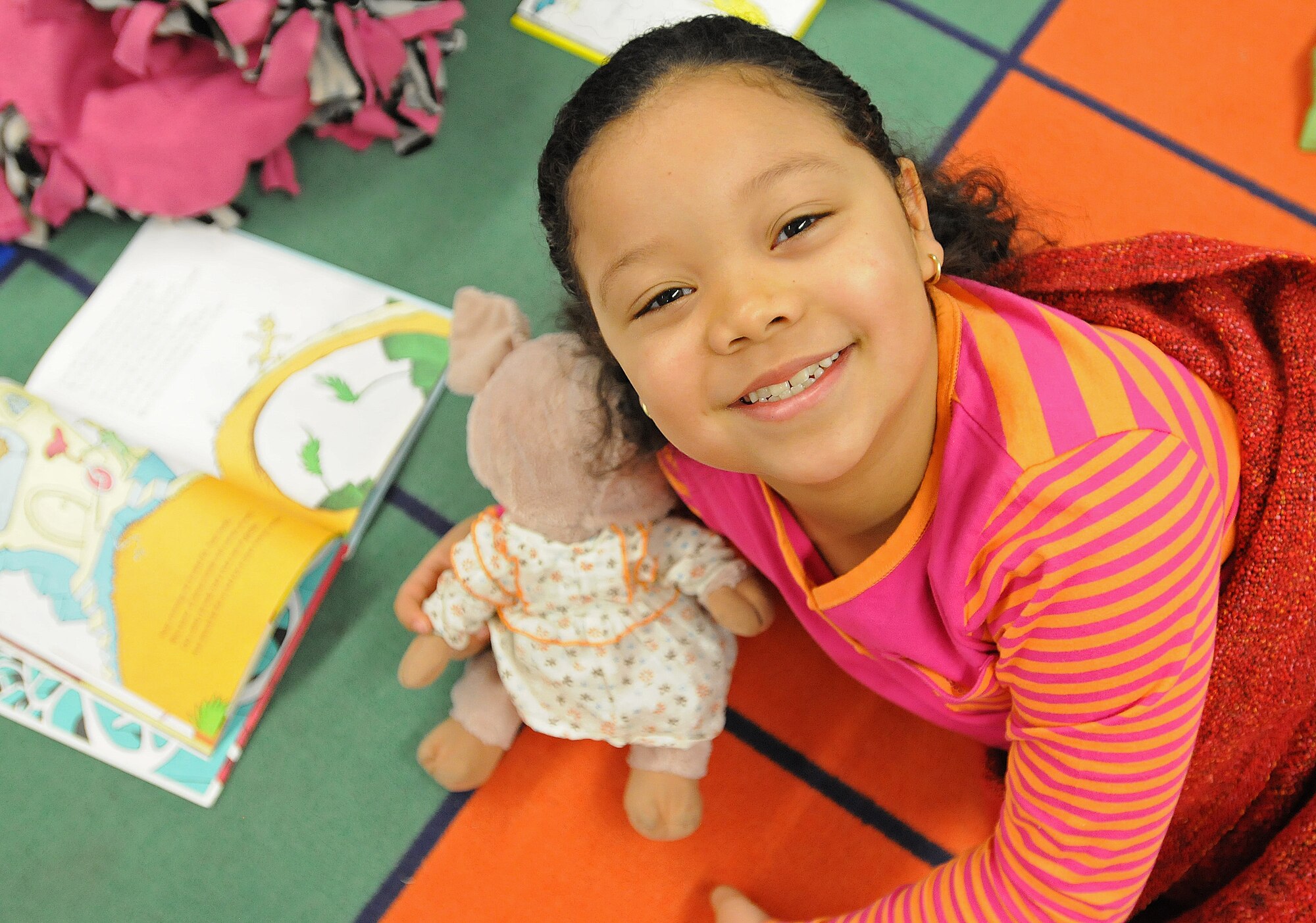 Jasmine Bass, daughter of Chief Master Sgt. Joanne Bass, 86th Operations Group superintendent, reads a book during Read Across America week Mar. 3, 2014, Ramstein Air Base, Germany. Read Across America is a week-long celebration, held the week of Dr. Seuss’ birthday, to teach children the importance of reading and education in schools across America and U.S. military installations overseas. (U.S. Air Force photo/Airman 1st Class Holly Mansfield)