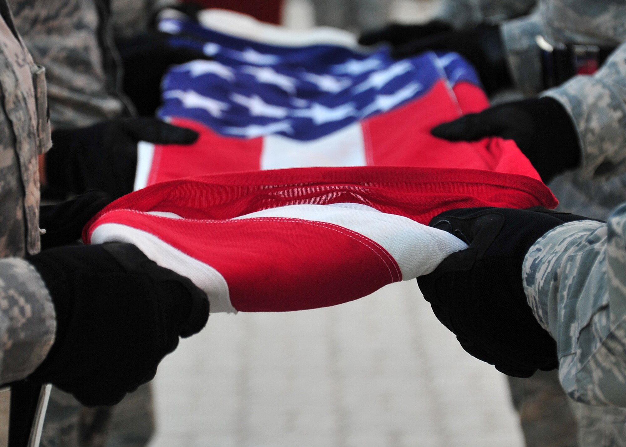 Members of the base honor guard fold the flag during a retreat ceremony at an undisclosed location in Southwest Asia, March 7, 2014. (U.S. Air Force photo by Staff Sgt. Michael Means/Released)