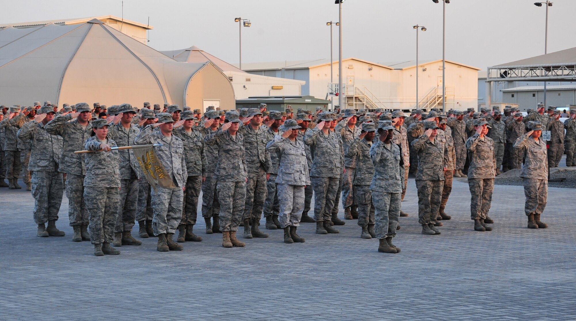 Members of the 380th Air Expeditionary Wing salute during the playing of Taps at an undisclosed location in Southwest Asia, March 7, 2014. The wing holds a monthly retreat ceremony honoring the military members who have died that month while serving. (U.S. Air Force photo by Staff Sgt. Michael Means/Released)