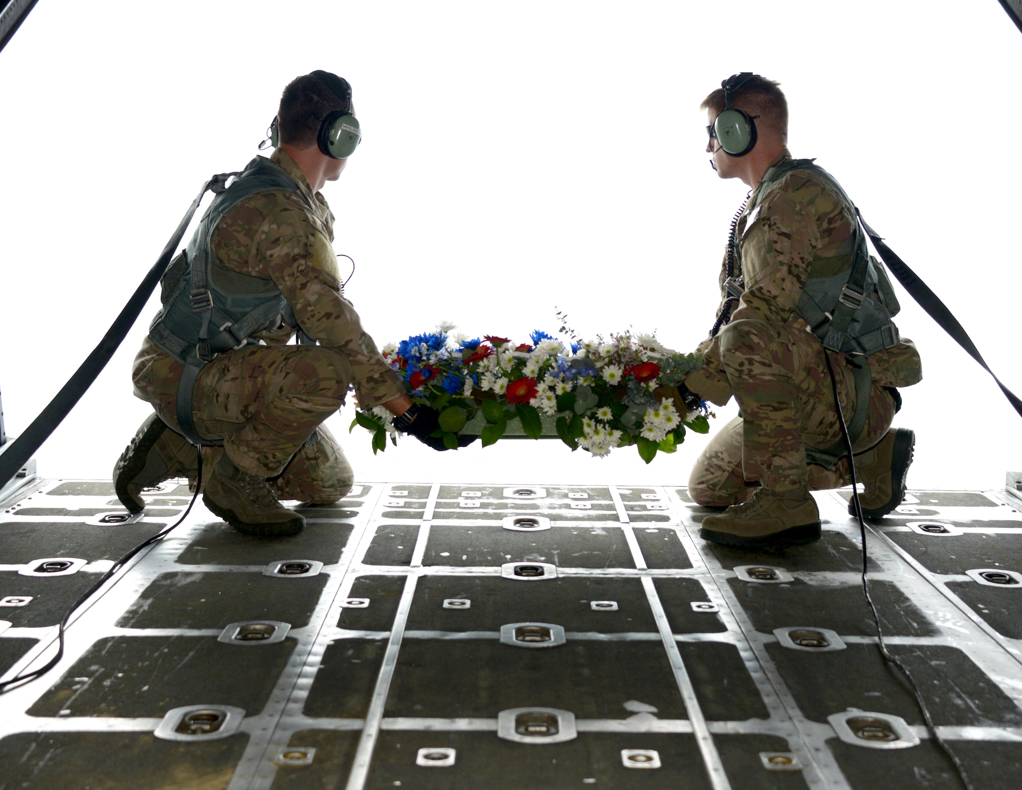 From left, Staff Sgt. Michael Wilson and Staff Sgt. Anthony Bliss, both loadmasters from the 1st Special Operations Squadron, prepare to drop the wreath from an MC-130H Combat Talon II off the coast of the Philippines Feb. 26, 2014 in memory of those who died in the crash of Stray 59.  The flight honors those who were lost 33 years ago when a 1st SOS MC-130E, call sign STRAY 59, crashed during an exercise killing eight crew members and 15 passengers. (U. S. Air Force photo by Tech. Sgt. Kristine Dreyer) 
