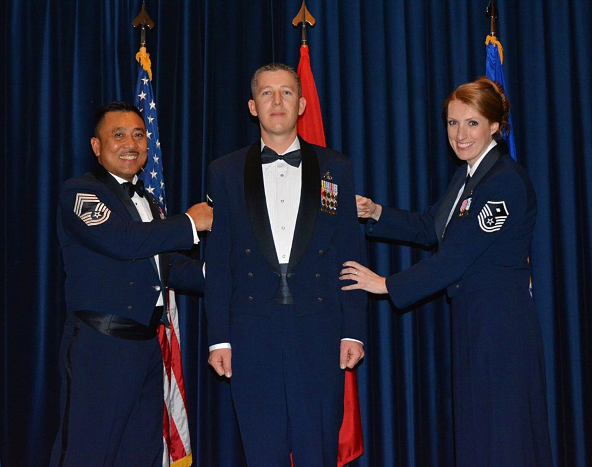 Master Sgt. Chris Rekrut, 728th Air Mobility Squadron Quality Assurance superintendent, is “tacked on” by Chief Master Sgt. Phillip Gawan, 728th superintendent, and his wife, Air Force Reserve Master Sgt. Corrine Rekrut. Rekrut, was recently promoted by means of the Stripes for Exceptional Performers program for his sustained exceptional performance at work and his involvement in the community. (Photo by Carla Bigger)