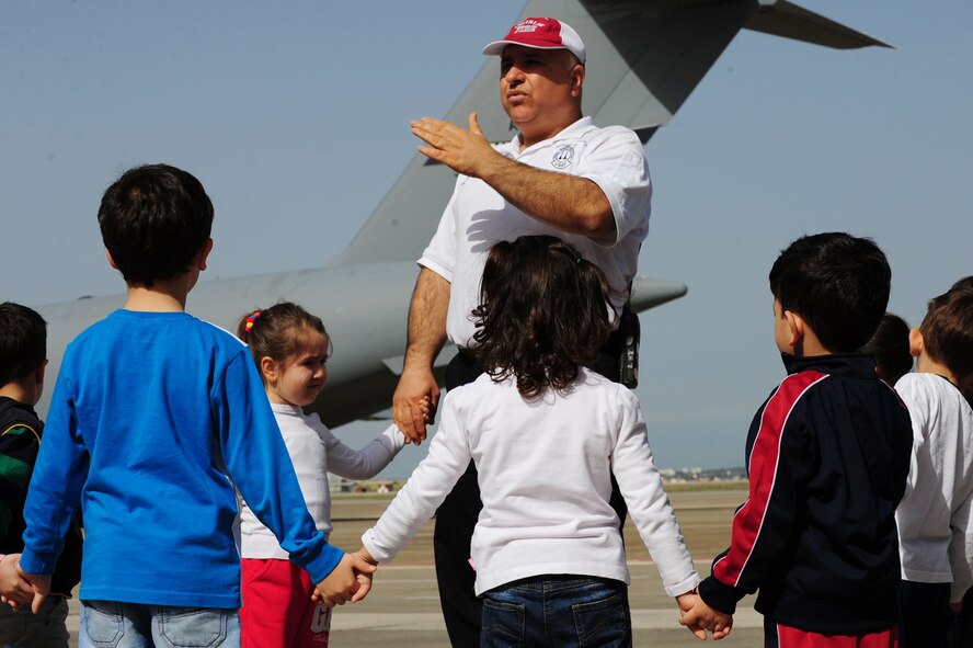 Turkish schoolchildren hold hands and listen to a briefing March 6, 2014, Incirlik Air Base, Turkey.  The Turkish schoolchildren visited both the 39th Force Support Squadron fabric care facility and the 39th Civil Engineer Squadron fire department for their weekly base facility tours.   (U.S. Air Force photo by Senior Airman Nicole Sikorski/Released) 