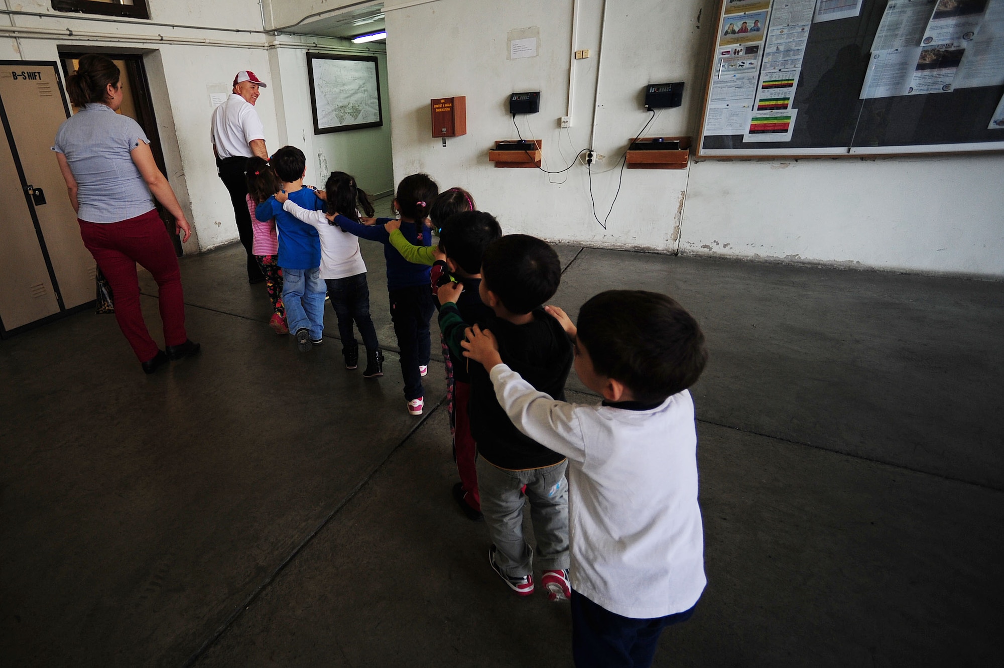 Turkish schoolchildren follow Muammer Ozpolat, 39th Civil Engineer Squadron fire inspector March 6, 2014, Incirlik Air Base Turkey.  The Turkish schoolchildren visited both the39th Force Support Squadron fabric care facility and the fire department for their weekly base facility tours.   (U.S. Air Force photo by Senior Airman Nicole Sikorski/Released) 