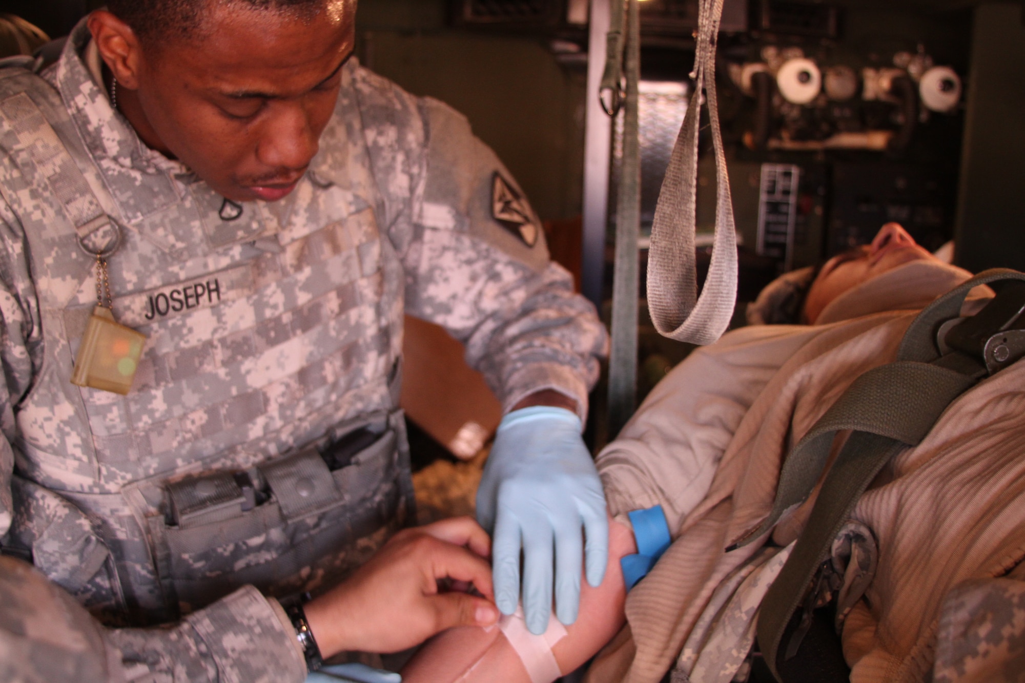 SUWON AIR BASE, Republic of Korea - Pfc. Joel Joseph, a combat medic with Headquarters and Headquarters Battery, 6-52 ADA, provides medical treatment to a casualty injured by a simulated improvised explosives blast during the Iron Resolve field training exercise at Suwon AB, Feb. 24. (Photo by Pfc. Shin, Young-Jae, 6-52 ADA Public Affairs)
