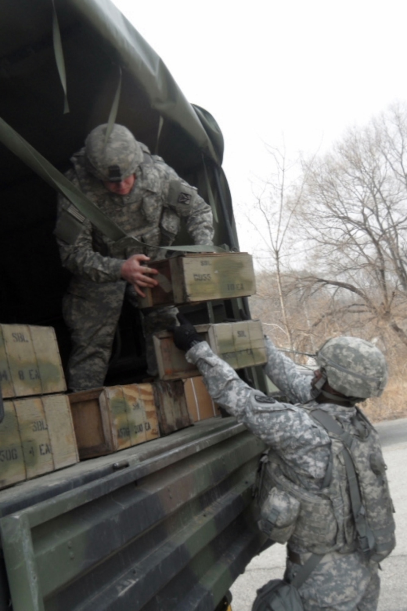 OSAN AIR BASE, Republic of Korea - Sgt. Raymond Calhoun (right), a supply sergeant with Headquarters and Headquarters Battery, 35th ADA Brigade, passes crates of ammunition to Pfc. Bryant Newsome, an HHB mechanic, during an ammunition retrieval exercise, Feb. 27. (U.S. Army photo by Capt. Ed Ellingson, 35th ADA PAO) 
