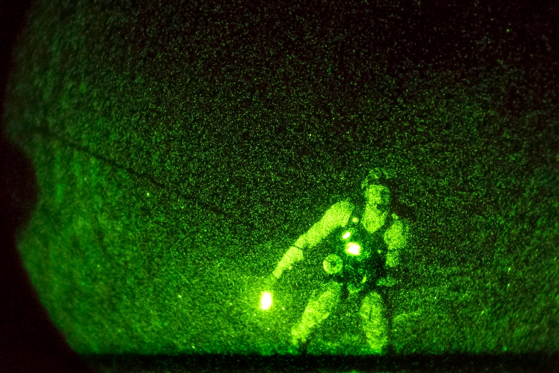 As seen through a night-vision device, an HH-60 Pave Hawk helicopter hoists a U.S. pararescueman as part of a search and rescue exercise off the coast of Djibouti, March 4, 2014.