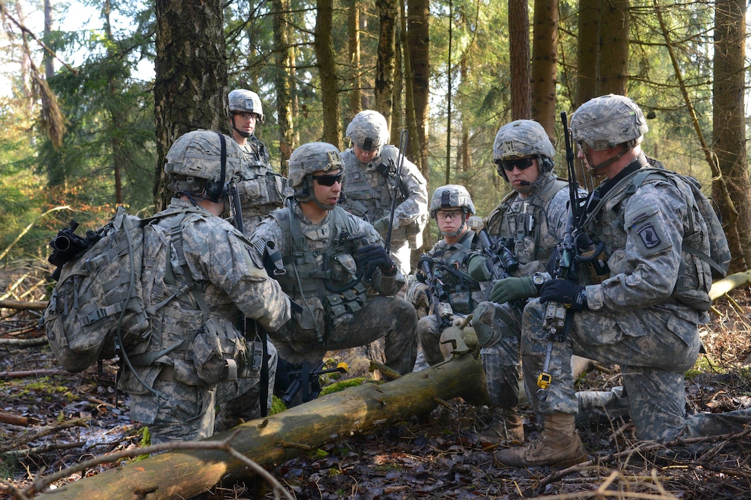 U.S. soldiers receive a mission update from their platoon leader during ...