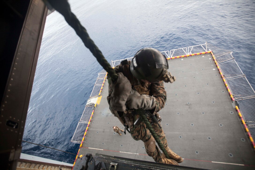 A Marine with the Maritime Raid Force, 31st Marine Expeditionary Unit, rappels from the back of an MV-22 Osprey onto the port-side elevator of the USS Bonhomme Richard (LHD 6) during a static fast-rope training event here, Mar. 1. The event was in preparation for certification exercises and also gave other Marines and sailors an opportunity to learn the skill. The 31st MEU is currently conducting amphibious integration training alongside Amphibious Squadron 11 while deployed for its regularly scheduled Spring Patrol.