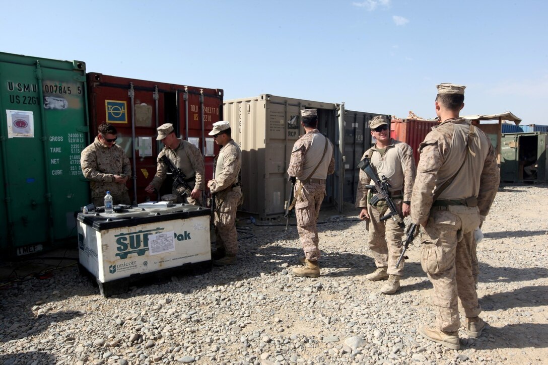 Corporal Shawn Gaffney, left, disbursing agent, Warfighter Express Services team, helps Marines and sailors withdraw money from their bank accounts, and issues and loads money onto their Eagle Cash Cards at the mobile exchange set up aboard Forward Operating Base Sabit Qadam, Helmand province, Afghanistan, March 7, 2014. The WES team is a small group of Marines who travel to FOBs throughout Regional Command (Southwest) to bring small comforts to Marines and sailors unable to make the trip to the exchange. (USMC Photo By: Sgt. Frances Johnson/ Released)