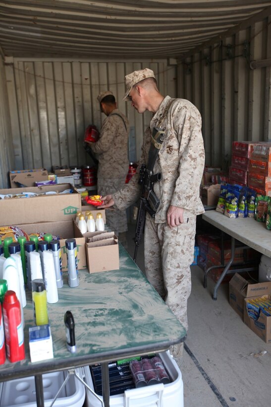 Two Marines browse through the mobile exchange, set up by the Warfighter Express Services team, aboard Forward Operating Base Sabit Qadam, Helmand province, Afghanistan, March 7, 2014. The WES teams travel throughout Regional Command (Southwest) every couple of weeks and set up a temporary mobile exchange, post office and disbursing station for Marines and sailors aboard different FOBs in order to ensure the service members have the items they need. (USMC Photo By: Sgt. Frances Johnson/ Released)