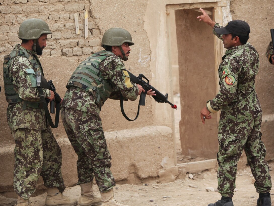 An instructor with Regional Corps Battle School, 215th Corps, Afghan National Army, instructs students before a Military Operations in Urban Terrain training exercise aboard Camp Bastion, Afghanistan, March 8, 2014. The exercise is part of the Regional Corps Battle School's four-week rifleman's course, which instills intermediate rifleman skills in ANA soldiers. The ANA soldiers' newly acquired training will give them an advantage on the battlefield as they return to their units throughout Afghanistan. (U.S. Marine Corps photo by Cpl. Cody Haas/ Released)