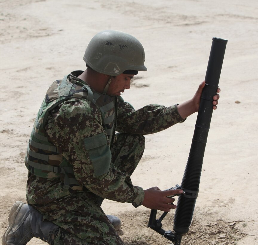 A soldier with 7th Kandak, 215th Corps, Afghan National Army, slowly squeezes the trigger of a M224 60 mm Lightweight Company Mortar System during a live-fire training exercise that marked the conclusion of a four-week mortarman's course aboard Camp Shorabak, Afghanistan Mar. 5, 2014. The course instilled basic mortar man skills as well as taught explosive ordnance disposal skills to approximately 40 ANA soldiers. The ANA soldiers newly acquired training will give them an advantage on the battlefield as they return to their units throughout Afghanistan. (U.S. Marine Corps photo by Cpl. Cody Haas/ Released)