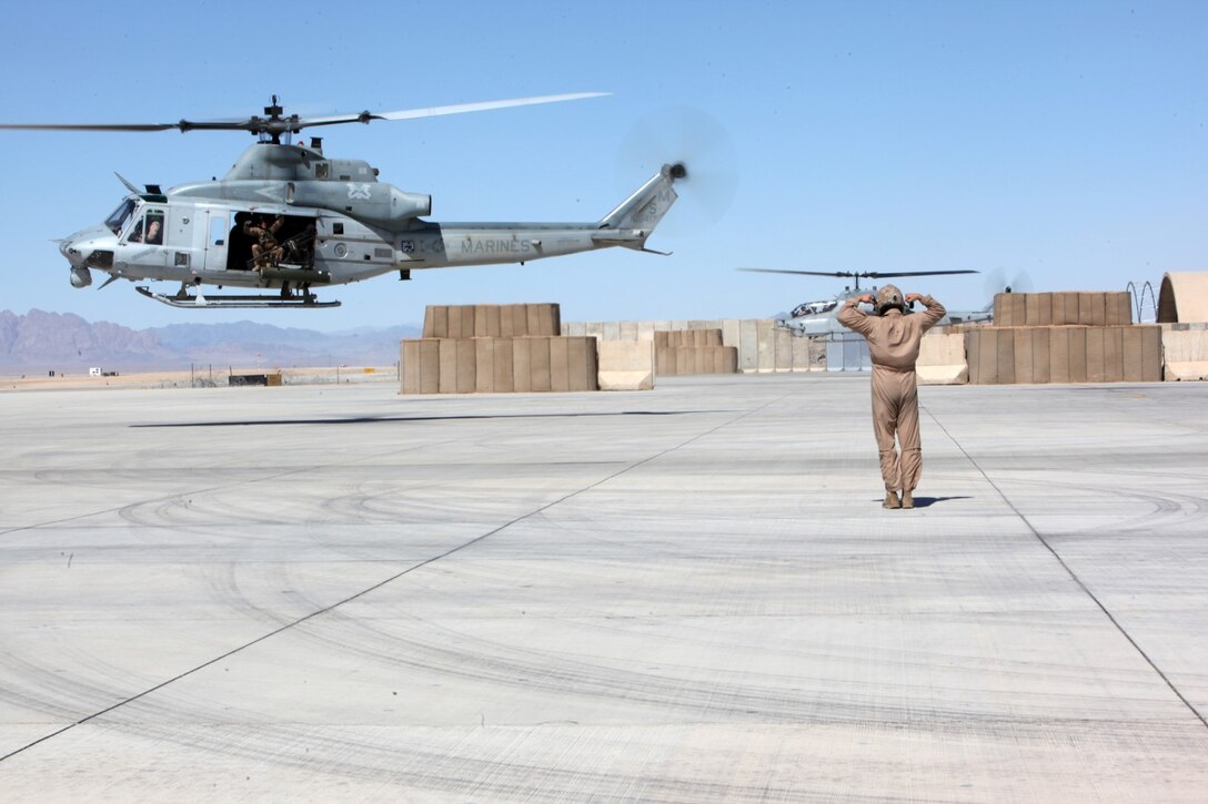 A crew chief with Marine Light Attack Helicopter Squadron 369 gives the "Gunfighter's Salute" to Brig. Gen. Mark R. Wise, assistant wing commander, 3rd Marine Aircraft Wing, and the Marines aboard the UH-1Y Huey as they leave for a mission, March 10, 2014. Brigadier Gen. Wise traveled from Marine Corps Air Station Miramar, Calif., to visit the air wing Marines deployed to Regional Command (Southwest) in Helmand province, Afghanistan.