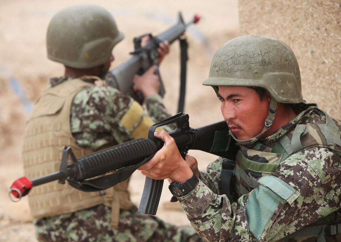 Soldiers with the 215th Corps, Afghan National Army, provide security during a Military Operations in Urban Terrain training exercise aboard Camp Bastion, Afghanistan, March 8, 2014. The exercise is part of the Regional Corps Battle School's four-week rifleman's course, which instills intermediate rifleman skills in ANA soldiers. The ANA soldiers' newly acquired training will give them an advantage on the battlefield as they return to their units throughout Afghanistan. (U.S. Marine Corps photo by Cpl. Cody Haas/ Released)