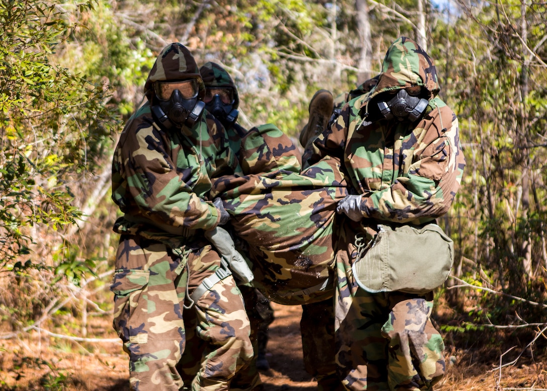 U.S. Marines with the 26th Marine Expeditionary Unit (MEU) assist another Marine in a simulated casualty training scenario during 26th MEU's chemical biological radiological and nuclear (CBRN) defense training aboard Camp Lejeune, N.C., March 11, 2014. The training consisted of classroom instruction and an obstacle course to familiarize Marines with CBRN defense equipment and procedures. (U.S. Marine Corps photo by Lance Cpl. Joshua W. Brown/Released) 