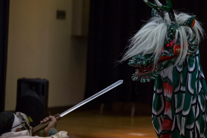 During a Kagura performance inside the Matthew C. Perry High School cafeteria aboard Marine Corps Air Station Iwakuni, Japan, two members of the Fire Snake Theater display the encounter between Susano-o, a Shinto god, and Yamata-no-Orochi, an eight-headed and eight-tailed serpent, as part of the Japanese American Society Culture Festival March 8, 2014. This is the 57th year JAS hosted the free festival aboard station, providing residents the opportunity to experience Japanese culture.