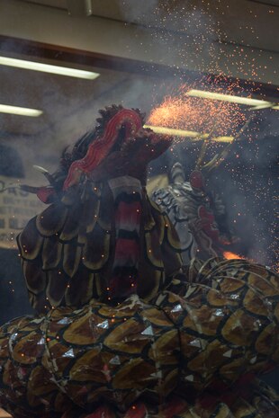A member of the Fire Snake Theater, clad in a dragon costume, uses fireworks to portray the beast’s fire-breathing effect during the Kagura performance inside of the Matthew C. Perry High School cafeteria as part of the Japanese American Society Culture Festival, March 8, 2014 aboard, Marine Corps Air Station Iwakuni, Japan. Performers depicted the mythological tale of Yamata-no-Orochi, an eight-headed and eight-tailed serpent.