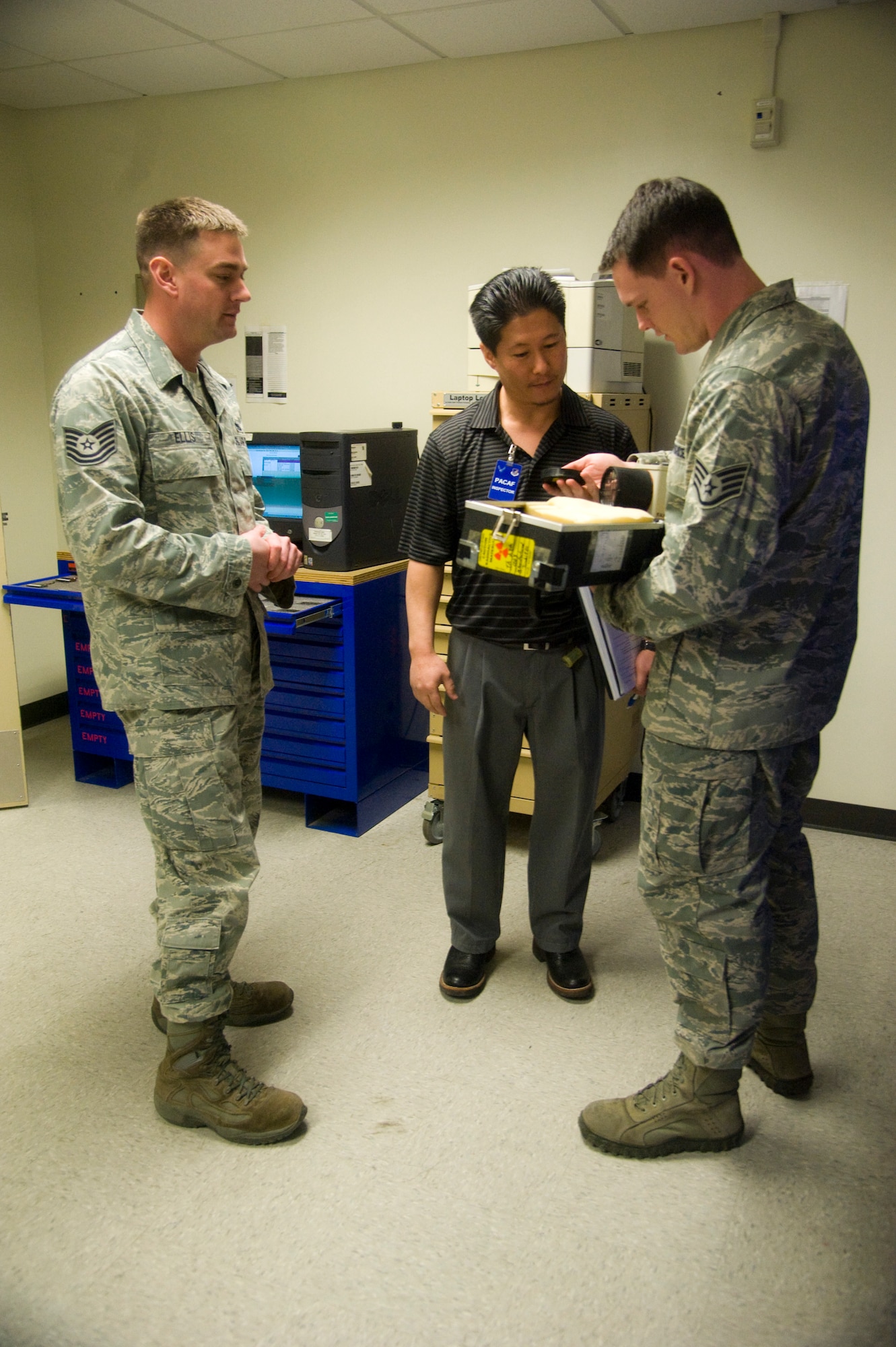 Sunny Kim, Occupational Health Organization inspector, inspects survey meter equipment used by the 8th Maintenance Squadron nondestructive inspection section, during a Unit Effectiveness Inspection conducted at Kunsan Air Base, Republic of Korea, Mar. 5, 2014. This UEI was the first to be conducted in Pacific Air Forces and is the newest way of inspecting a base, which includes interviewing Airmen and inspecting critical areas of the base for effectiveness. (U.S. Air Force photo by Staff Sgt. Jessica Haas/Released)