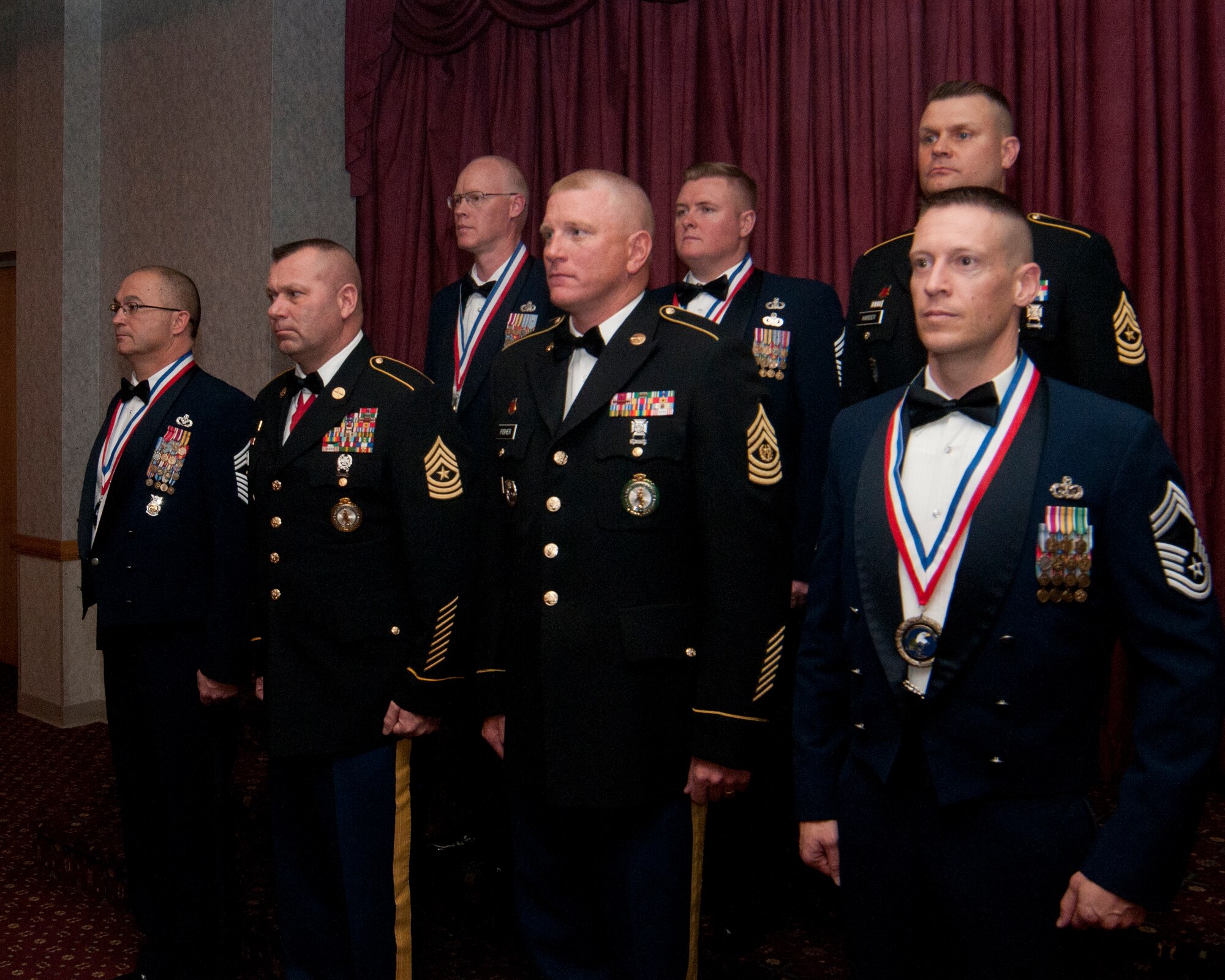 Newly promoted chief master sergeants and sergeants major in the Wyoming Air National Guard and National Guard stand on stage in the Trail’s End Club March 7, 2014, prepared to be given the Senior NCO Charge, a declaration of their responsibilities as senior NCOs, in sight of their peers and family members in attendance of a recognition ceremony held in the promotees’ honor. (U.S. Air Force photo by Airman 1st Class Jason Wiese)