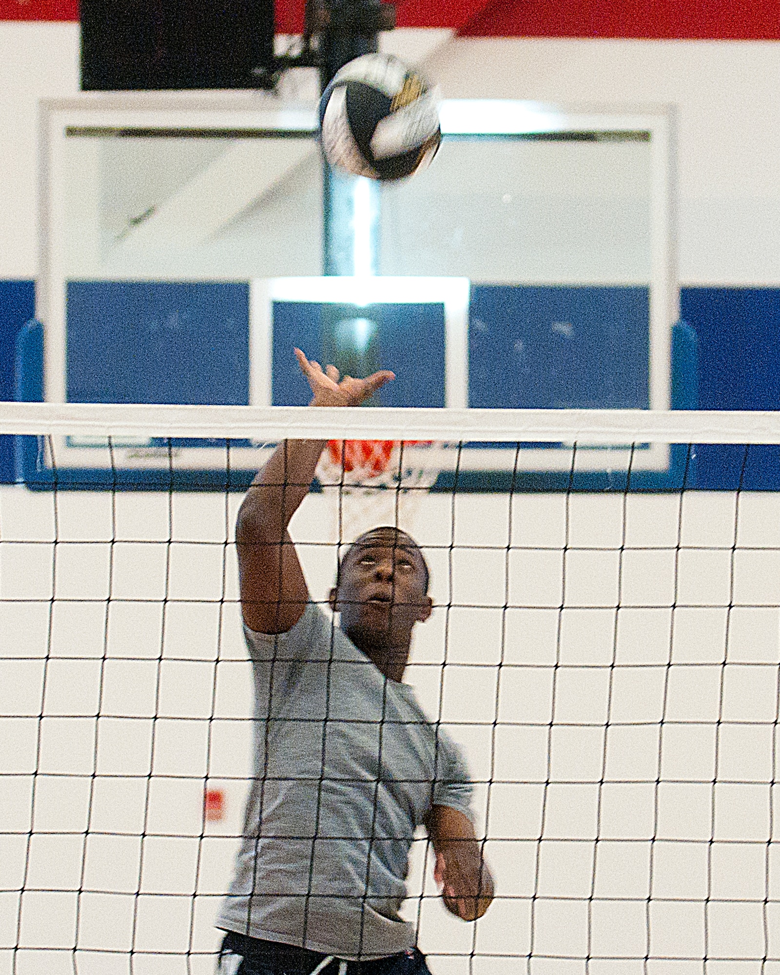 140311-F-CQ929-040 Airmen 1st Class Andrew Madden, 90th Comptroller Squadron customer service technician, spikes the ball over the net March 11 in the Freedom Hall Fitness Center. (U.S. Air Force photo by Airman Malcolm Mayfield)