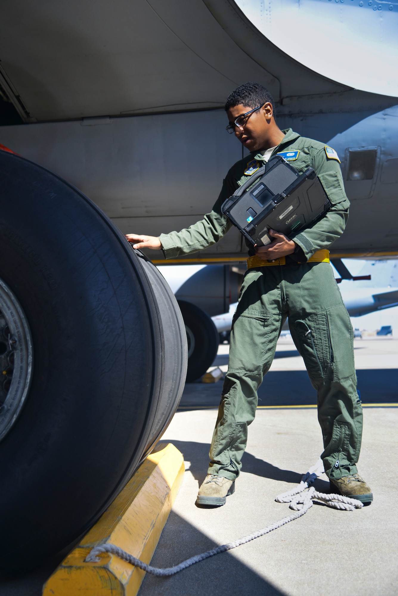 Senior Airman Alexis Aponte, 22nd Aircraft Maintenance Squadron assistant flying crew chief, inspects the tire of a KC-135 Stratotanker March 11, 2014, at McConnell Air Force Base, Kan. He refers to an electronic preflight checklist to verify the functionality of aircraft parts. Flying crew chiefs are frequently called upon to travel with a few days or hours notice. (U.S. Air Force photo/Airman 1st Class John Linzmeier)