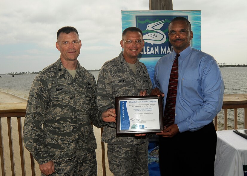 Shawn Hamilton, Department of Environmental Protection Northwest District director, presents a Florida Clean Marina plaque to Col. Douglas Dudley, 1st Special Operations Mission Support Group commander, and Lt. Col. Jim Beaty, 1st Special Operations Force Support Squadron commander, at Hurlburt Field, Fla., March 12, 2014. The Florida Department of Environmental Protection and Clean Boating Partnership recognized the Hurlburt Field Marina as the newest member of Florida’s Clean Marina Program. (U.S. Air Force photo/Staff Sgt. Jeff Andrejcik)