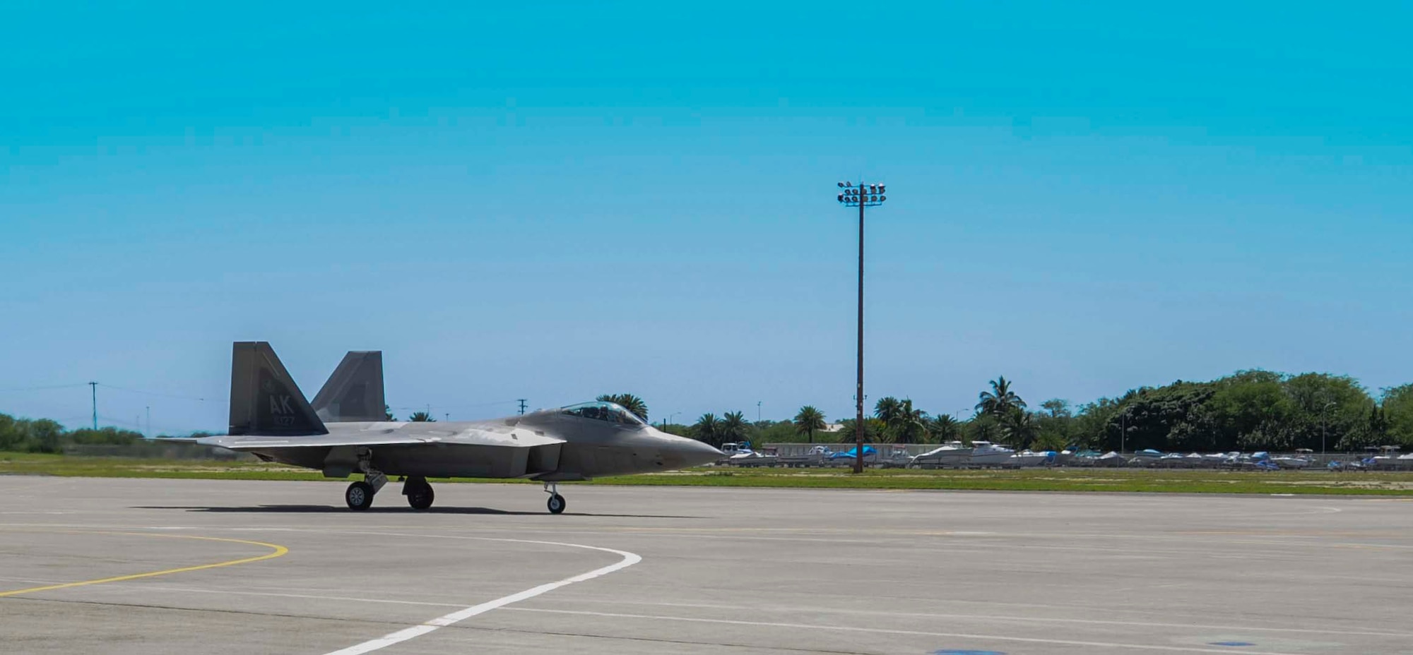 An F-22 Raptor from the 525th Fighter Squadron at Elmendorf Air Force Base, Alaska, lands on the flightline at Joint Base Pearl Harbor-Hickam, Hawaii, March 11, 2014. The Alaskan fighters are on temporary duty to Hawaii for “Operation Cope Thaw.” (U.S. Air Force photo/Tech. Sgt. Terri Paden)