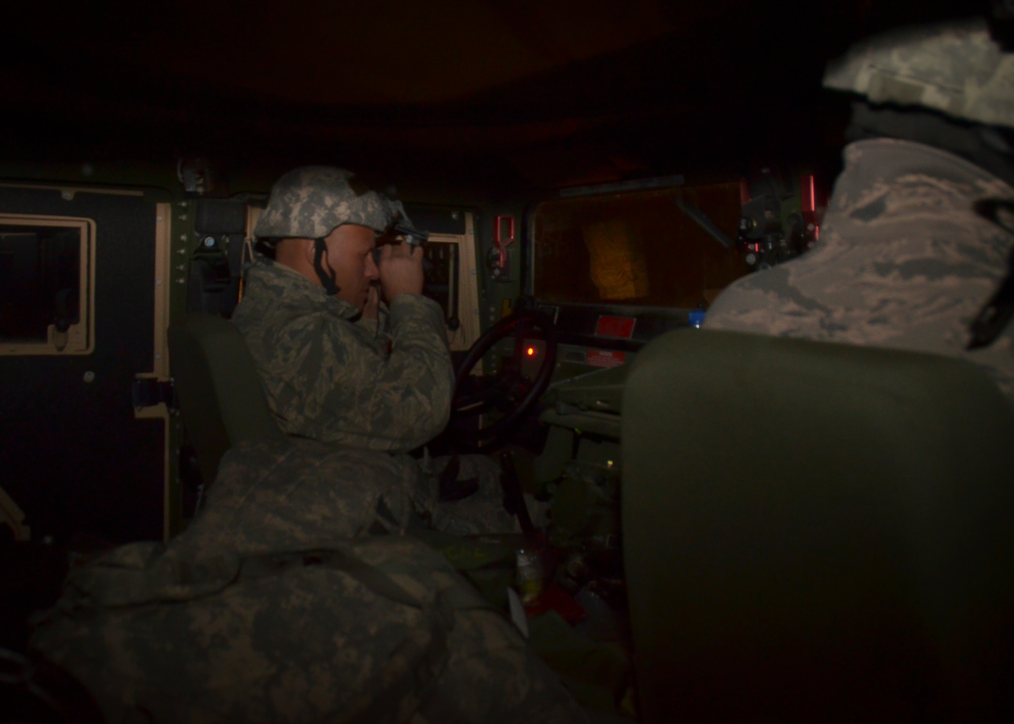 U.S. Air Force Senior Master Sgt. Matthew Knight with the security forces squadron of the 128th Air Refueling Wing, Wisconsin Air National Guard, adjusts his night vision component in order to drive a Humvee from the 757th Transportation Battalion, U.S. Army Reserve, Milwaukee, in complete darkness on the roads of the Richard Bong State Recreation Area, Kansasville, Wis., Feb. 28, 2014.  The 128th Security Forces Squadron trained with U.S. Army Reserve tactical vehicles to qualify in nighttime driving and night vision training during the March unit training assembly.  (U.S. Air National Guard photo by Staff Sgt. Jenna V. Lenski/Released)