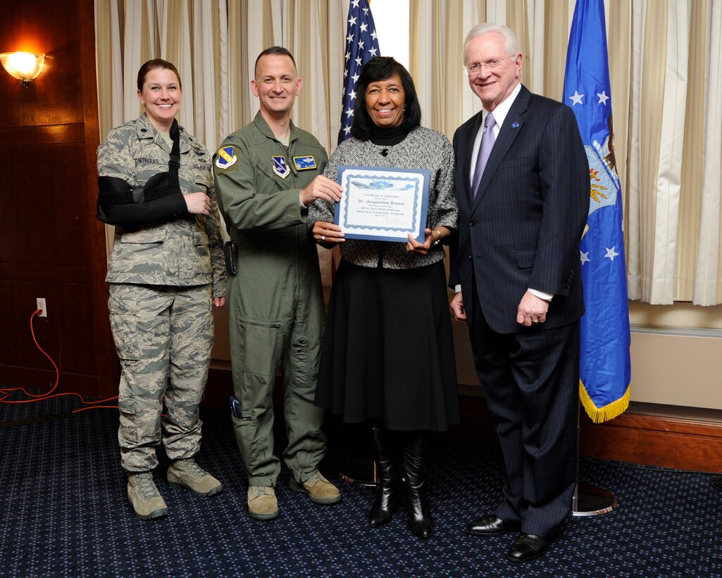 Dr. Jacqueline L. Brown, second from the right, Prince George’s Community College director of community government affairs, receives an honorary commanders induction certificate from Col. Bill Knight, 11th Wing commander, and Mr. Jim Estepp, JBA senior honorary commander, far right, during a ceremony on Joint Base Andrews, Md., March 7, 2014. Brown is the honorary commander for the 11th Operations Support Squadron. She is joined by Lt. Col. Anne Marie Contreras, 11 OSS commander, far left. (U.S. Air Force photo/ Airman 1st Class Nesha Humes)
