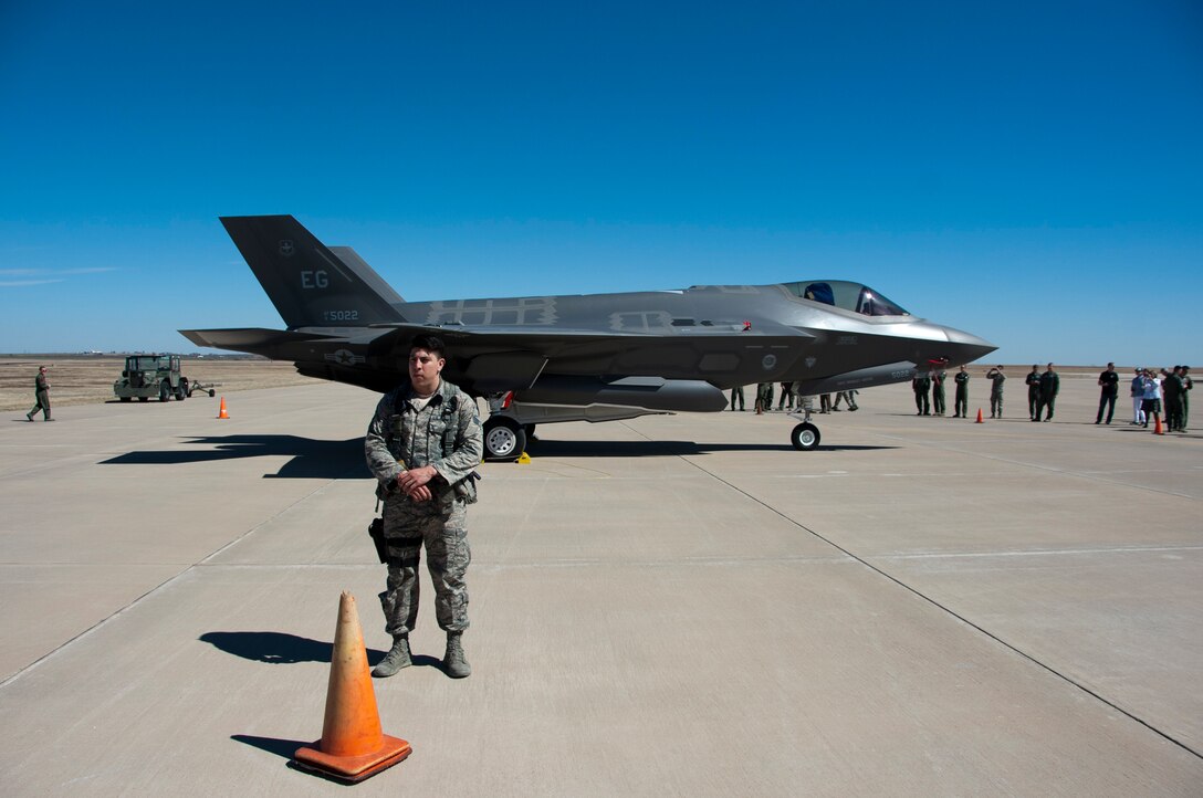 Senior Airman Edward Ramos, 82nd Security Forces Squadron, Stands just behind the cordon perimeter protecting the F-35 lightning II while Sheppard Airmen take the opportunity to see it up close March 11, 2014 at Sheppard Air Force Base, Texas from Eglin Air Force Base, Fla., as part of a hurricane evacuation exercise that would allow aircraft from Eglin to migrate to Sheppard if threatened by a hurricane. (U.S. Air Force photo/Airman 1st Class Robert L. McIlrath)


