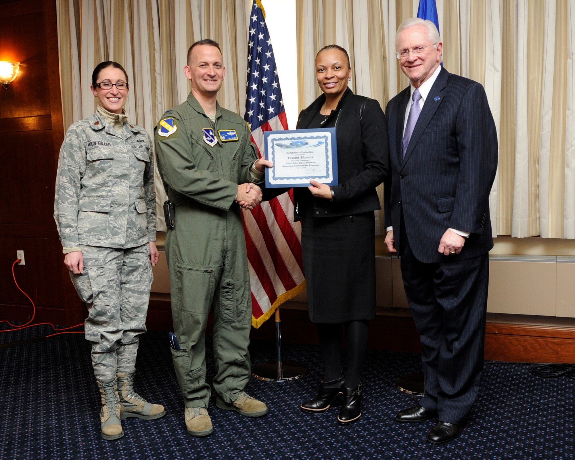 Ms. Tammi Thomas, second from the right, Chief of Staff to the President of Bowie State University, receives an honorary commander’s induction certificate from Col. Bill Knight, 11th Wing commander, and Mr. Jim Estepp, JBA senior honorary commander, far right, during a ceremony on Joint Base Andrews, Md., March 7, 2014. Thomas is the honorary commander for the 11th Force Support Squadron. She is joined by Maj. Kelli Moon, 11 FSS operations officer, far left. (U.S. Air Force photo/ Airman 1st Class Nesha Humes)
