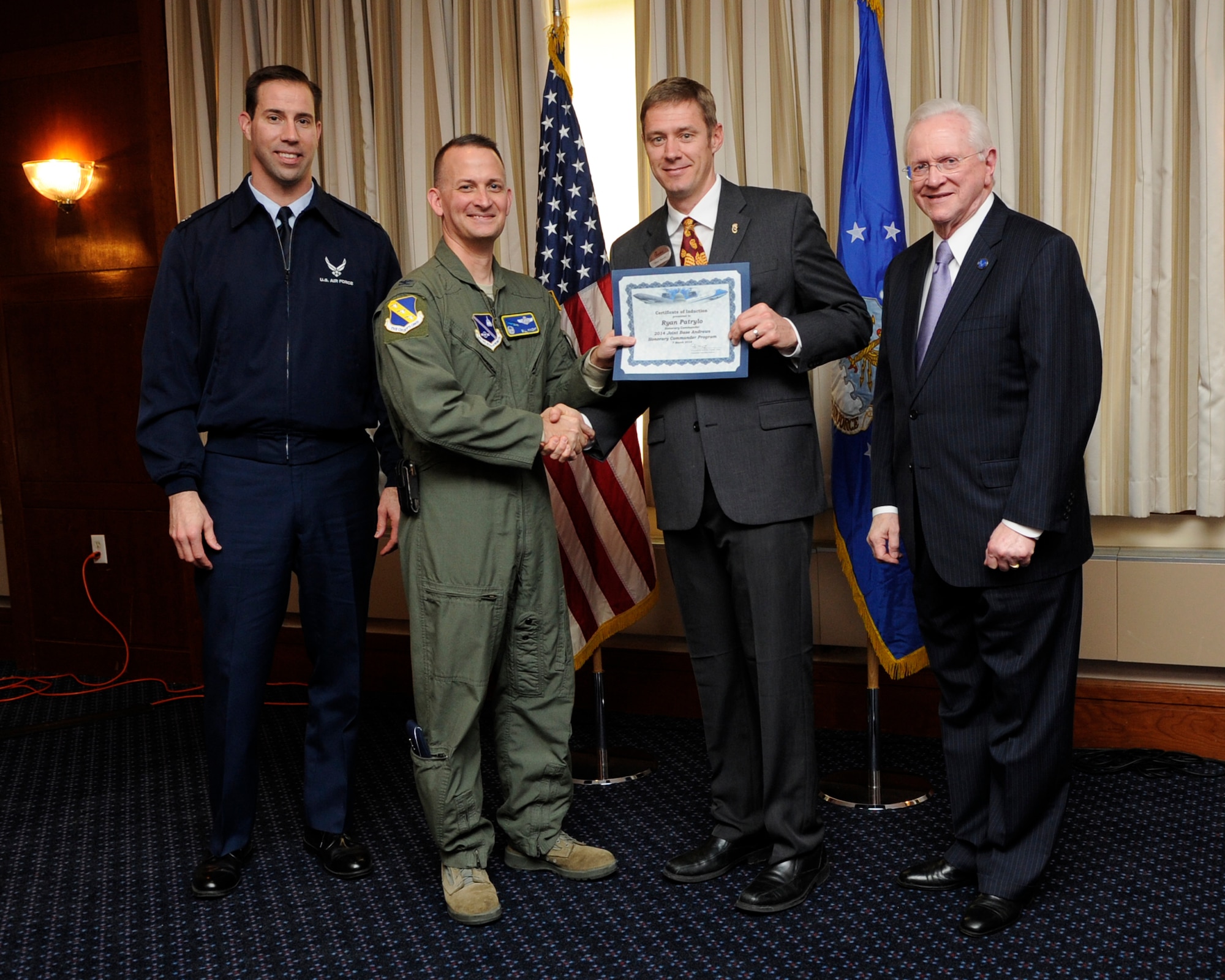 Mr. Ryan Patrylo, second from the right, owner of Chick-Fil-A, Brandywine, Md, receives an honorary commander’s induction certificate from Col. Bill Knight, 11th Wing commander and Mr. Jim Estepp, JBA senior honorary commander, right, during a ceremony on Joint Base Andrews, Md., March 7, 2014. Patrylo is the honorary commander for the 89th Maintenance Group. He is joined by Lt Col. Jason Bock, left, deputy commander 89 MXG, far left. (U.S. Air Force photo/ Airman 1st Class Nesha Humes)
