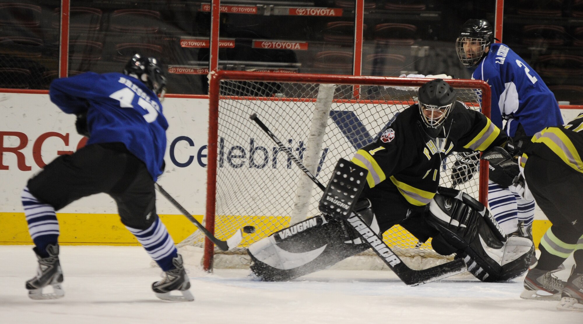 Joint Base McGuire-Dix-Lakehurst Hockey Team's Air Force Staff Sgt. Cory Bressler scores the final point against the Philadelphia Fire Department’s goalie, Ted Damajanovic, March 6, 2014, at the Wells Fargo Center in Philadelphia. JB MDL defeated PFD 4-3 during the special game meant to highlight the base’s hockey program resurgence. (U.S. Air Force photo by Airman 1st Class Sean M. Crowe/Released)