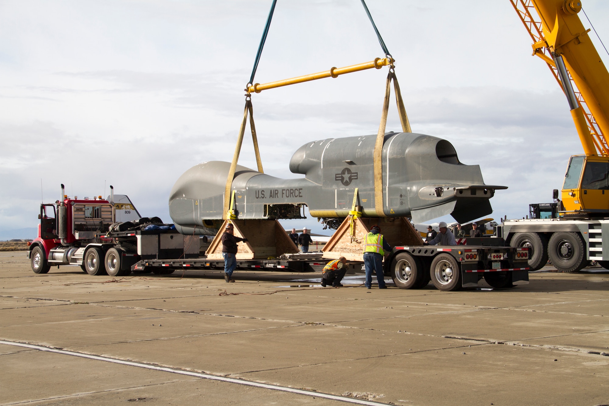 Personnel from the Navy, Beale Air Force Base, Calif., and Edwards AFB, Calif., help load an Edwards RQ-4B Global Hawk Block 20 remotely piloted aircraft (tail number 2016) atop 53-foot truck trailer Mar. 1. The Global Hawk T/N 2016 will be transferred to the Persistent Maritime Unmanned Aircraft Systems Program Office (PMA-262) located at Naval Air Station Patuxent River, Md., to be used in MQ-4C Triton device development and maintenance training. (U.S. Air Force photo by Brad White)