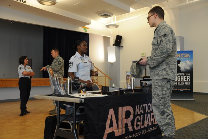 Master Sgt. Nilka Alleyene (left), an Air National Guard in-service recruiter, speaks to an active duty Airmen during a job fair at Beale Air Force Base, Calif., March 12, 2014. As a member of the Air Guard, Airmen have the opportunity to re-train into a new career field. (U.S. Air Force photo by Airman 1st Class Bobby Cummings/Released)