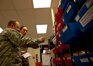 Airman 1st Class Jennie Short, 628th Communications Squadron official mail center, sorts mail with Col. Jeffery DeVore, Joint Base Charleston commander during a 628th Air Base Wing leadership visit to the OMC March 7, 2014. 
Each month DeVore and his staff visit a different 628th agency and receive a hands-on tutorial on how to do a specific job. As mail room staff, Devore, Chief Master Sgt. Mark Bronson, 628th ABW command chief and Master Chief Petty Officer Joseph Gardner, Naval Support Activity Command Master Chief, learned to pitch, sort and deliver mail, metered and stamped. (U.S. Air Force photo/Staff Sgt. William A. O’Brien)
