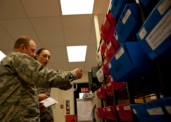 Airman 1st Class Jennie Short, 628th Communications Squadron official mail center, sorts mail with Col. Jeffery DeVore, Joint Base Charleston commander during a 628th Air Base Wing leadership visit to the OMC March 7, 2014. 
Each month DeVore and his staff visit a different 628th agency and receive a hands-on tutorial on how to do a specific job. As mail room staff, Devore, Chief Master Sgt. Mark Bronson, 628th ABW command chief and Master Chief Petty Officer Joseph Gardner, Naval Support Activity Command Master Chief, learned to pitch, sort and deliver mail, metered and stamped. (U.S. Air Force photo/Staff Sgt. William A. O’Brien)

