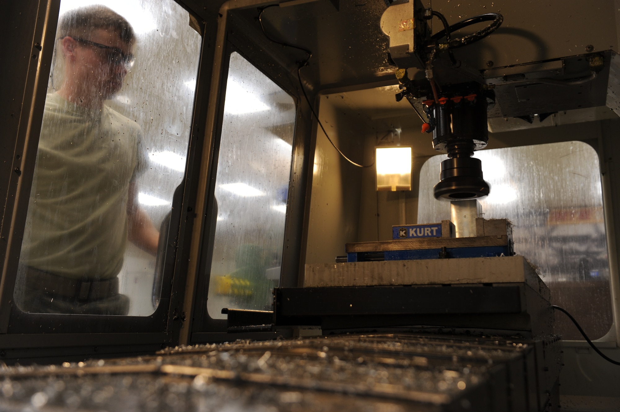 Senior Airman Dustin Blakney, a 19th Equipment Maintenance Squadron aircraft metal technologies journeyman, watches as he manually controls a computer numeric control machine to cut a piece of scrap material March 11, 2014, at Little Rock Air Force Base, Ark. Airmen from AMT can repair any metallic items that are broken as well as manufacture aircraft parts from engineering drawings. (U.S. Air Force photo by Airman 1st Class Cliffton Dolezal)