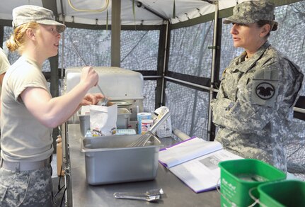 Chief Warrant Officer Pamela Null (right), U.S. Army Reserve Command food service advisor, quizzes Spc. Shera Tunstall, a food service specialist with the 851st Transportation Company based in Sinton, Texas, on her knowledge of food preparation during the Philip A. Connelly food service competition Feb. 22 at Joint Base San Antonio-Camp Bullis. The competition is an annual evaluation by the Department of the Army, in conjunction with the International Food Service Executives Association, to recognize the skills and achievements of Army food service specialists. The 851st, a subordinate unit of the 4th Sustainment Command (Expeditionary) based at JBSA-Fort Sam Houston, is one of four finalists throughout the Army Reserve and Army National Guard. The competition evaluates not only the team’s ability to cook, but also how well they set up a tactical field kitchen site and the overall ability of the food service section. The Soldiers were evaluated in 10 different categories, including field food safety, food quality, site layout and attitude.

Photo by Master Sgt. Robert R. Ramon