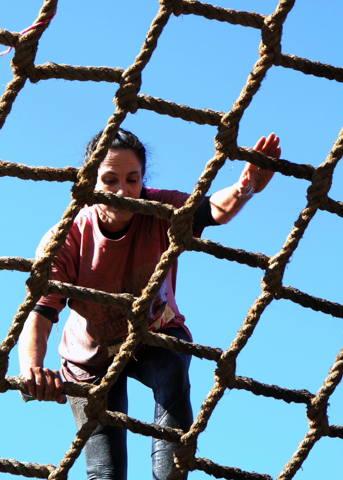 Master Sgt. Barbara Sosebee, 315th Mission Support Group career advisor at Joint Base Charleston, S.C., climbs a cargo net during the Rugged Maniac 5K mud run held March 8, 2014, at Boone Hall Farms in Mount Pleasant, S.C. Sosebee ran the obstacle-type challenge course with the “Mudruckers,” a team of reservists serving with the 315th Airlift Wing. (U.S. Air Force photo by Senior Airman Meredith A. H. Thomas)