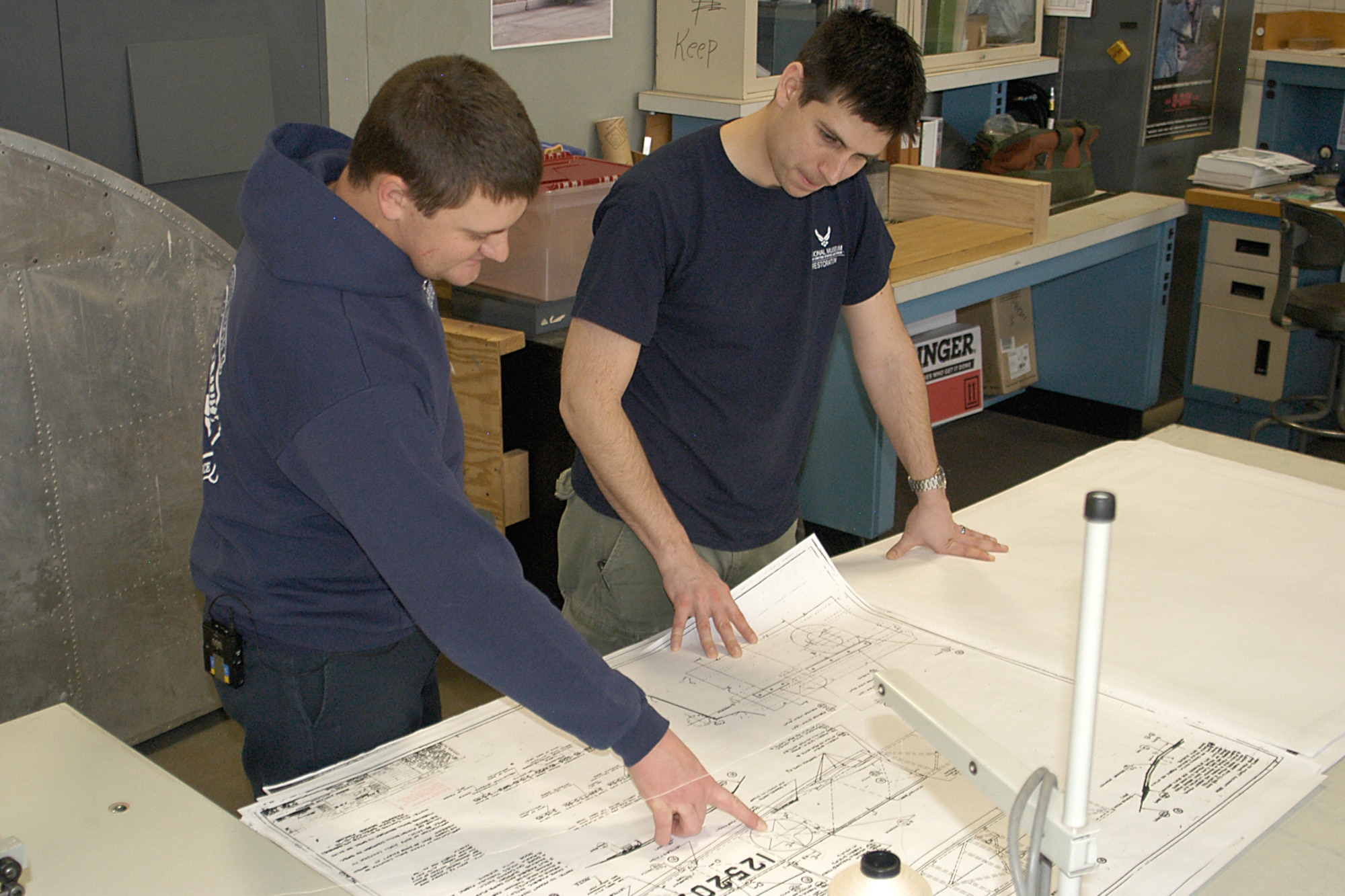 DAYTON, Ohio -- National Museum of the U.S. Air Force restoration specialists Nick Almeter and Casey Simmons examine blue prints for the Stearman PT-13D Kaydet.  Plans call for the aircraft to be part of an expanded Tuskegee Airman exhibit in the World War II Gallery at the National Museum of the U.S. Air Force. (U.S. Air Force photo by Ken LaRock) 
