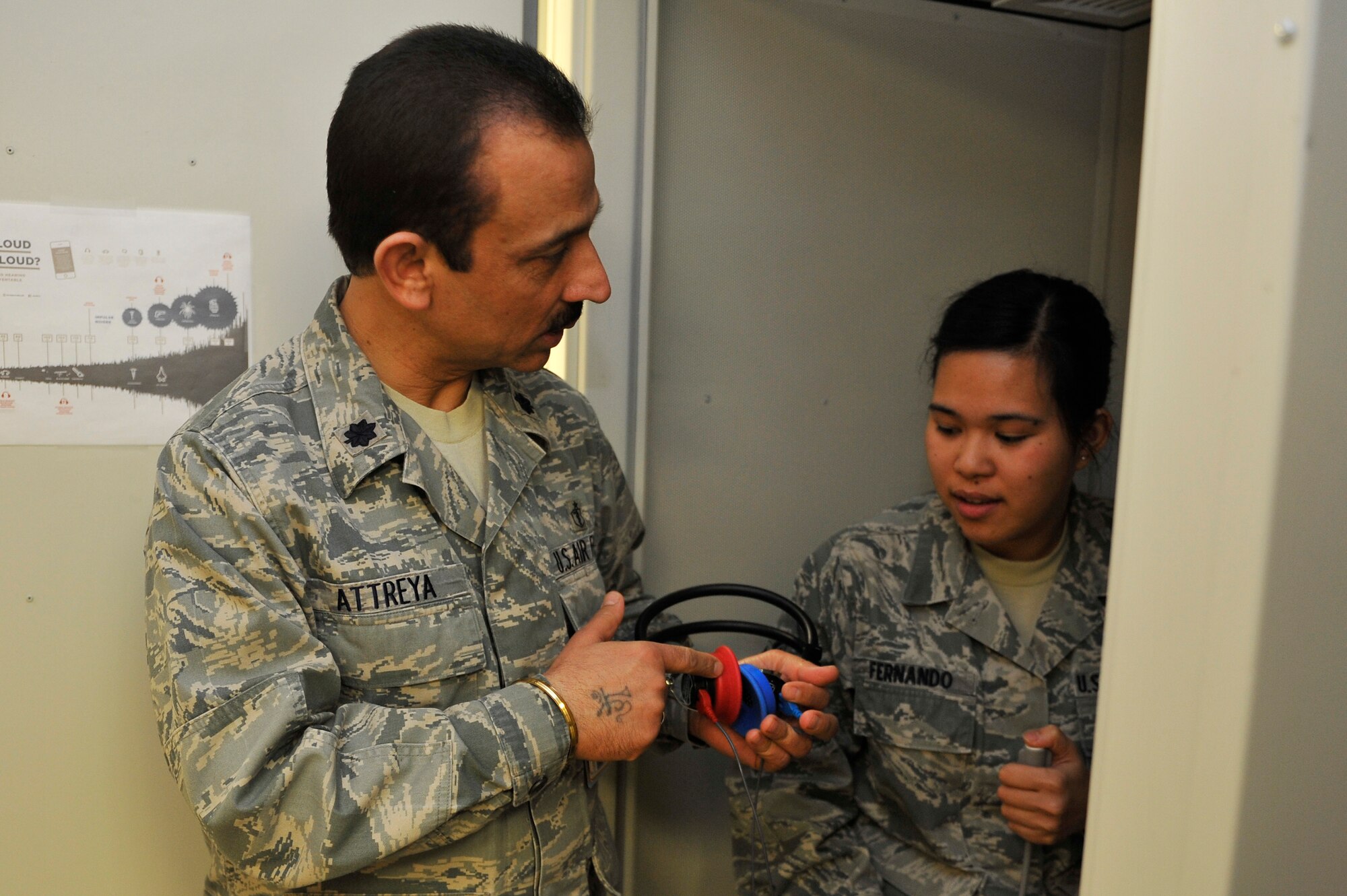 Lt. Col. Anoop Attreya helps with a hearing test in the Public Health Clinic March 7. Attreya joined the Air Force in 1995. (U.S. Air Force photo/Airman 1st Class Kiana Brothers)