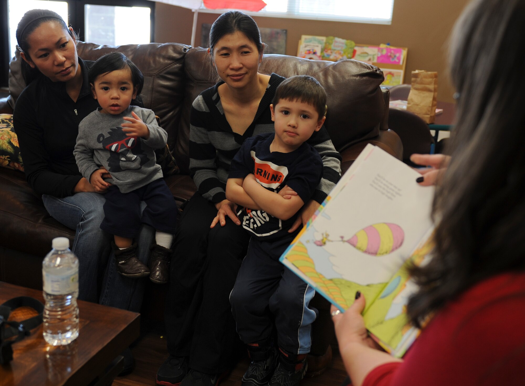 Parents and their children listen as Tammy Nelson-Burris reads "Oh, The Places You'll Go," by Dr. Seuss March 3. Children listened to the story, had snacks, and participated in an art activity to celebrate Dr. Seuss's birthday and Read Across America Day. Nelson-Burris is the Blue Star Families Scott Chapter director. (U.S. Air Force photo/Airman 1st Class Sarah Hall-Kirchner)