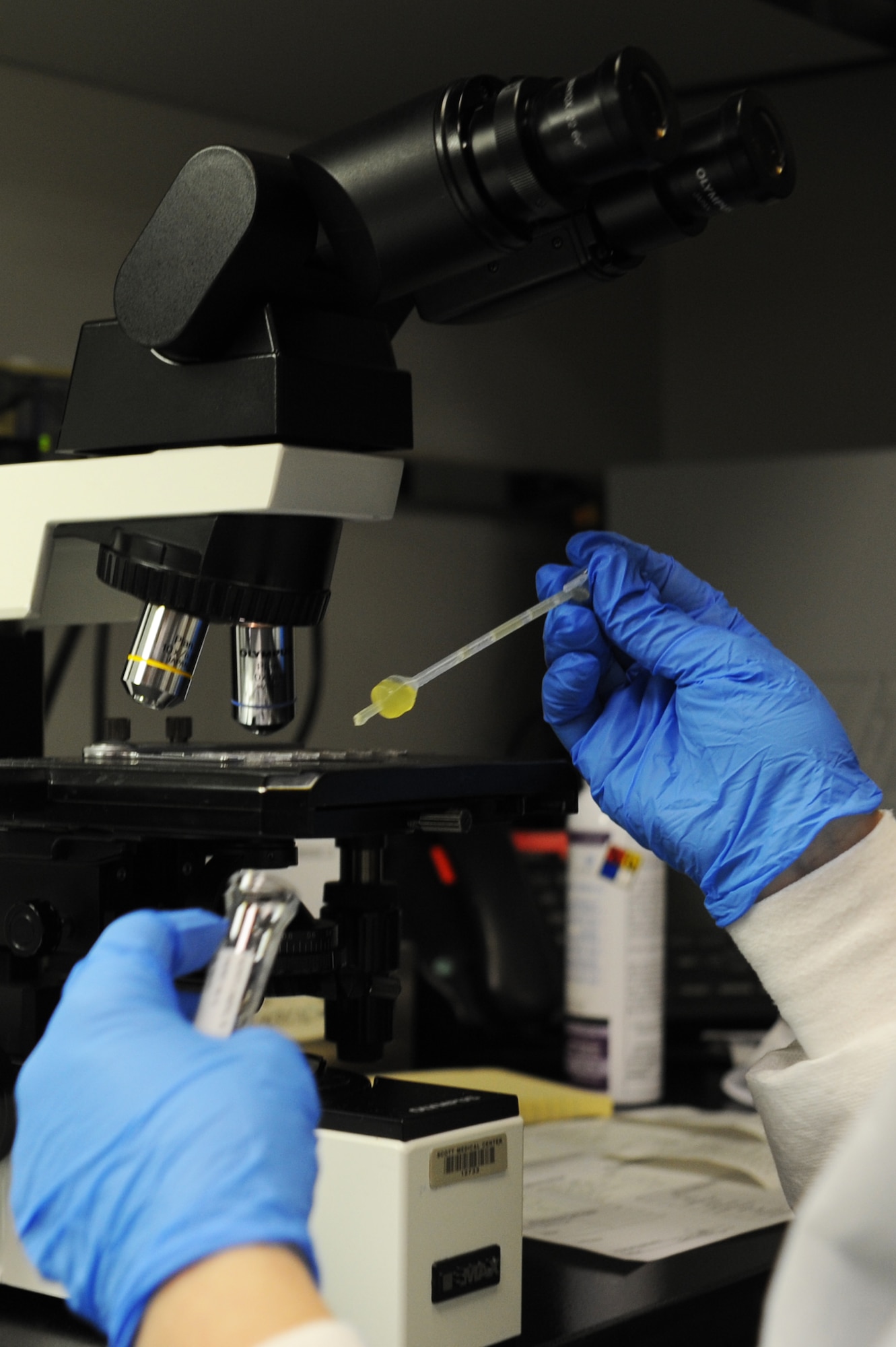 A laboratory technician drops a urine sample onto a slide to examine it underneath a microscope. Samples are viewed under the microscope to help identify any health concerns in patients. (U.S. Air Force photo/Airman 1st Class Megan Friedl)
