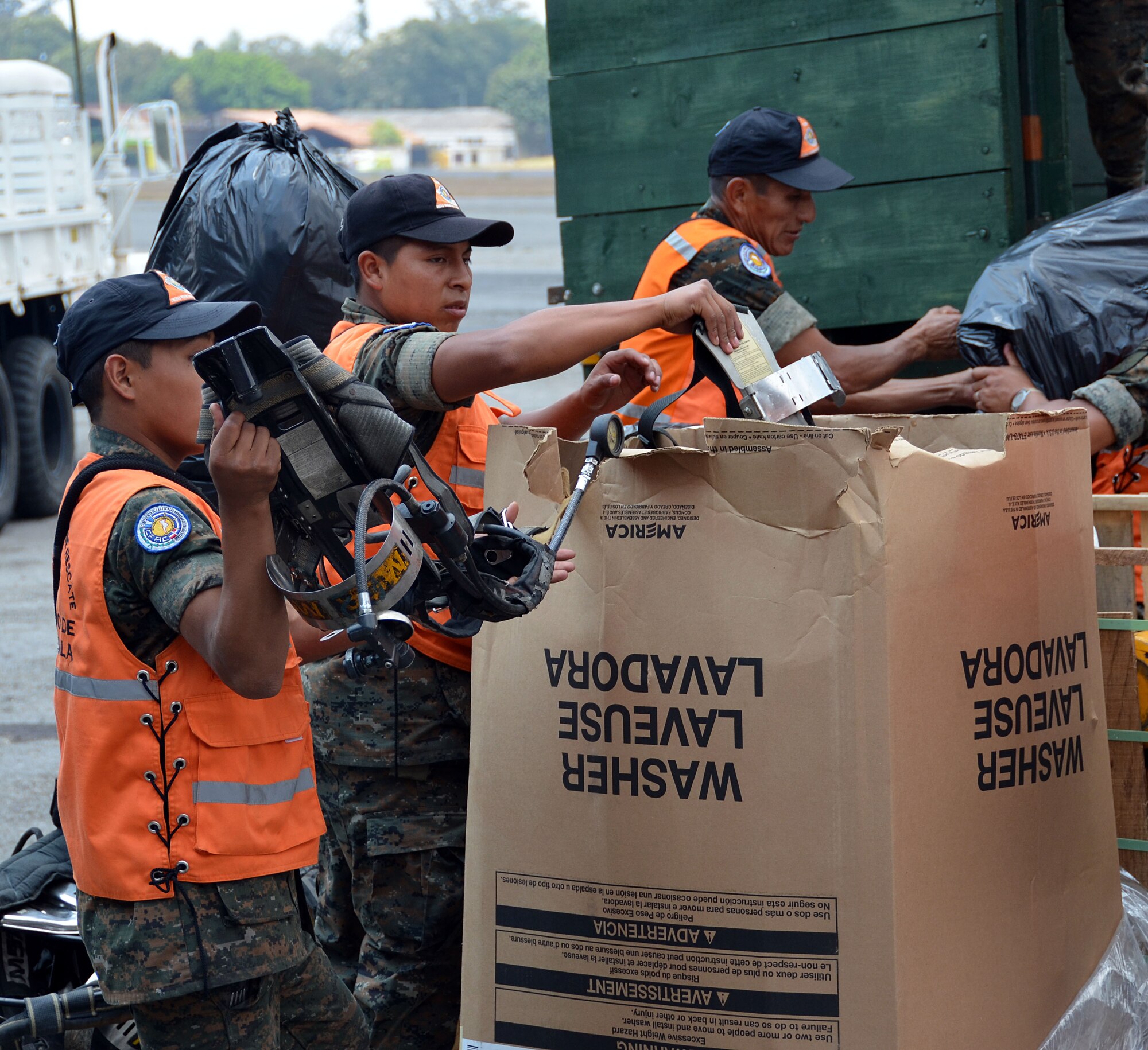 Guatemalan volunteers and police load trucks with cargo from the Patriot Wing C-5 in Guatemala City, Guatemala March 8, 2014. The 11-man Patriot Wing crew delivered 20 tons of humanitarian aid to Guatemala City, Guatemala, March 9. (U.S. Air Force photo/SSgt. Kelly Goonan) 