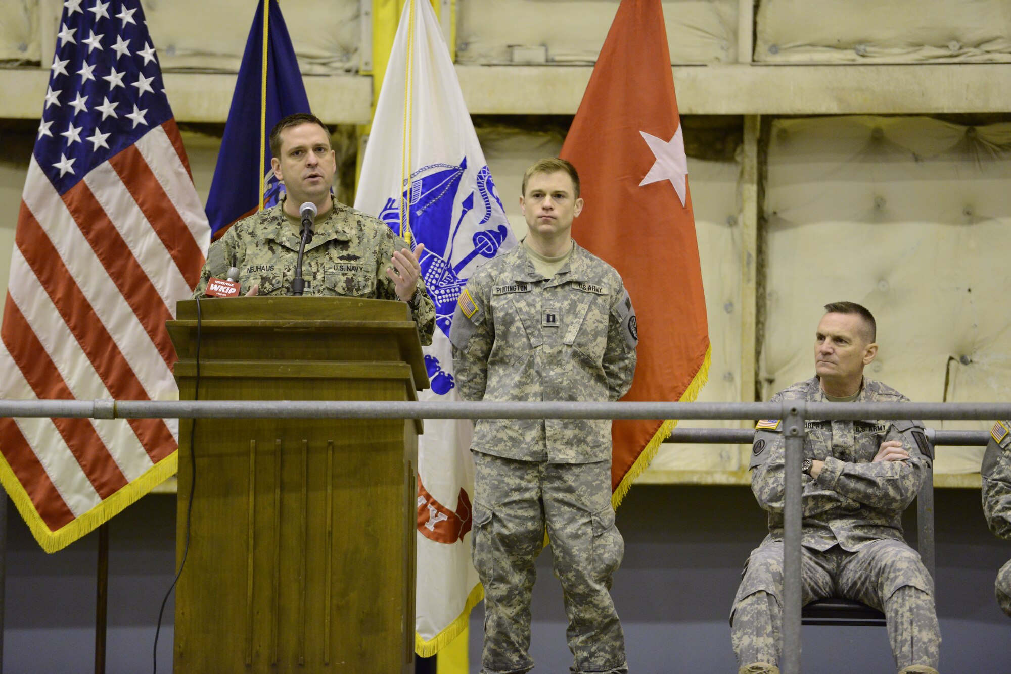 Guest Speaker, Orange County Executive, Steven M. Neuhaus, with the New York Naval Milita/Naval Reserve, addresses Guardsmen, their family members, friends and fellow Soldiers during a pre-deployment ceremony for the 1569th Transportation Company conducted in a hangar at the 105th Airlift Wing, March 9, 2014. (U.S. Air National Guard photo by Tech. Sgt. Michael OHalloran/Released)