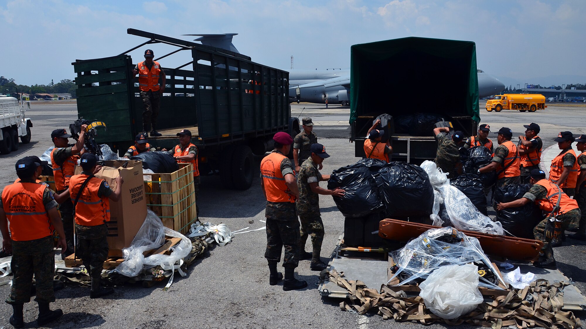 Guatemalan volunteers and police load trucks with cargo from the Patriot Wing C-5 in Guatemala City, Guatemala March 8, 2014. The 11-man Patriot Wing crew delivered 20 tons of humanitarian aid to Guatemala City, Guatemala, March 9. (U.S. Air Force photo/SSgt. Kelly Goonan) 