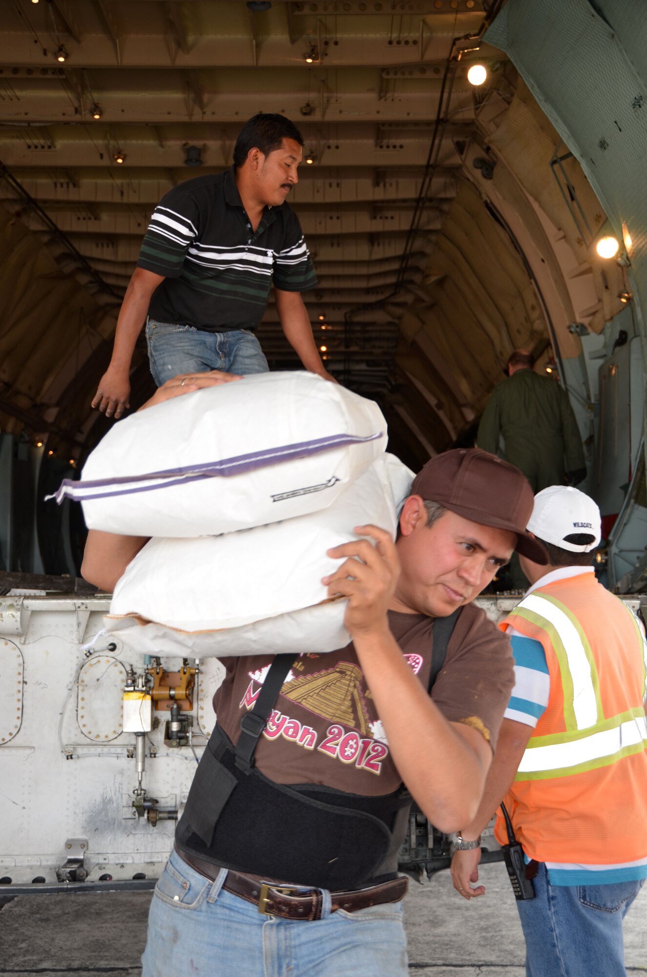 Guatemalan volunteers assist Westover aircrew with the removal of 800-pounds of corn from the Patriot Wing C-5 in Guatemala City, Guatemala March 8, 2014. The 11-man Patriot Wing crew delivered 20 tons of humanitarian aid to Guatemala City, Guatemala, March 9. (U.S. Air Force photo/SSgt. Kelly Goonan) 